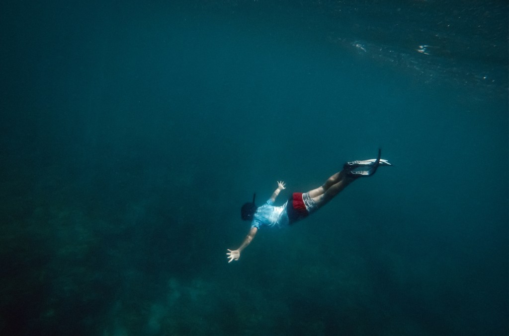 Freediver ascending slowly with calm expression â knowing your limits while freediving-a-man-freediving-benefits-of-freediving